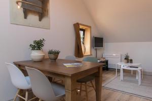 een eetkamer met een houten tafel en stoelen bij Atelier Botanie luxury short stay apartment in Hasselt