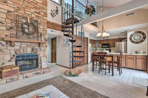 a kitchen and living room with a fireplace and a spiral staircase at 1 Mi to Shops and Dining Idyllic Lakeside Getaway! in Osage Beach