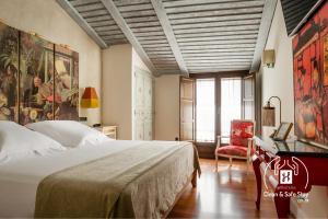 Un dormitorio con una cama, una mesa y una silla. en YIT La Casona del Arco, en Baeza