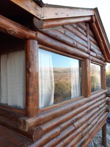 una ventana en una cabaña de madera con vistas en Cabaña de Montaña, La Casita Mina Clavero CBA en Mina Clavero