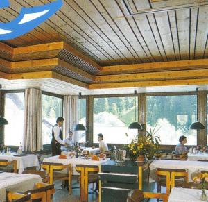 un hombre de pie en un comedor con mesas en Hotel Albula & Julier, en Tiefencastel