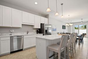 a kitchen with white cabinets and a table and chairs at Fortebello Beachside - 156 in Indian Harbour Beach
