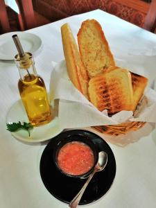 einen Tisch mit einem Teller Brot und einer Schüssel Sauce in der Unterkunft Casa Rural Parada Real in Garganta la Olla