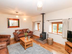 a living room with a couch and a stove at 2 Colby House Barn in Colby