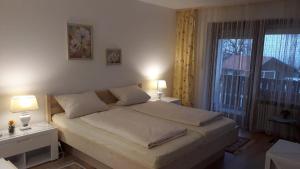 ein Schlafzimmer mit einem Bett mit zwei Lampen und einem Fenster in der Unterkunft Ferienwohnung Ritter in Missen-Wilhams