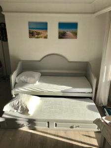 - 2 lits jumeaux dans une chambre avec 2 photos sur le mur dans l'établissement Résidence 4 etoiles Port Marine, à Sainte-Maxime