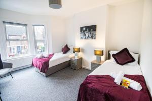 ein Schlafzimmer mit 2 Betten und einem Stuhl darin in der Unterkunft New Contractor House & M1 Access & LLA & Dunstable in Luton