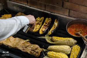 a person is cooking corn on the grill at Libélula Cabaña- Alojamiento rural in Duitama