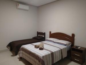 a bedroom with a bed with a stuffed animal on it at Sítio Pé da Serra - Pousada Rural in Capitólio +45 photos