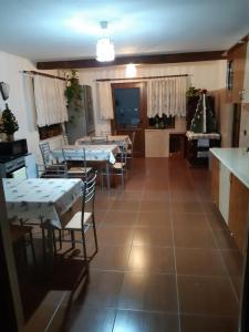 een keuken en eetkamer met tafels en stoelen bij Agropensiunea Căprioara in Mintia