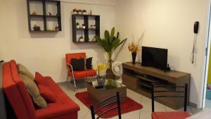 a living room with a red couch and a tv at Apartamento no centro de São Paulo in Sao Paulo