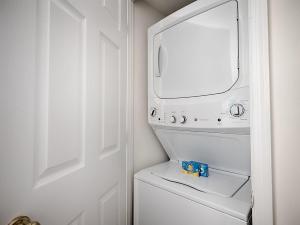 アーリントンにあるNational at Courthouse Placeの白いランドリールーム(洗濯機、鏡付) +5枚の写真