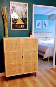 sypialnia z łóżkiem i wiklinową szafką w obiekcie Résidence du Haurat w mieście Gujan-Mestras
