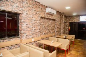 um restaurante com mesas e cadeiras e uma parede de tijolos em Hotel São Bento em Marabá