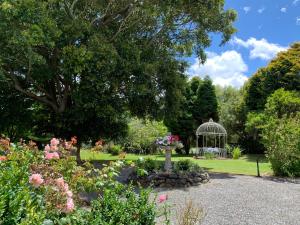 a garden with a gazebo and flowers at Karamana Homestead (1872) in Coromandel Town