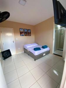 een slaapkamer met een bed en een tv. bij Âncora Suítes Arraial do Cabo in Arraial do Cabo