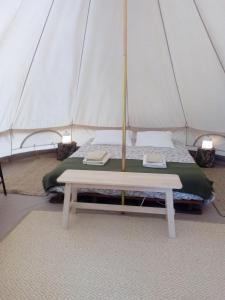 a bed in a tent with a table in it at Monte da Tojeirinha in Montargil
