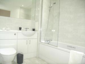 a bathroom with a shower and a toilet and a sink at New Central Woking 1 and 2 Bedroom Apartments with Free Gym, close to Train Station in Woking +32 photos