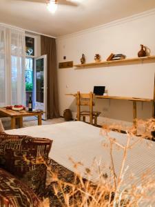 a bedroom with a bed and a table and a desk at Bjnihouse, guest house in Bjni