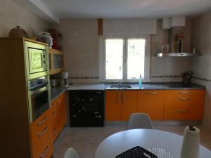 a kitchen with orange cabinets and a table in it at Apartamento Binies in Isaba