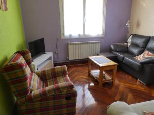 sala de estar con 2 sillas y sofá en Apartamento Binies, en Isaba
