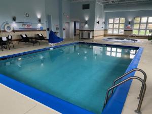 duży basen z niebieską wodą w budynku w obiekcie Holiday Inn Express Wixom, an IHG Hotel w mieście Wixom
