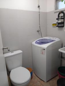 a white bathroom with a toilet and a sink at Brejatuba Residence! Conforto e lazer em excelente condomínio in Guaratuba