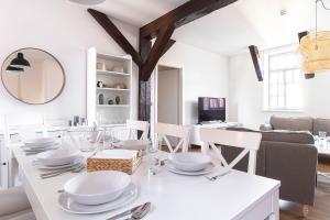 a white dining room with a white table and chairs at Ferienwohnungen BUNTER HOF Quedlinburg in Quedlinburg