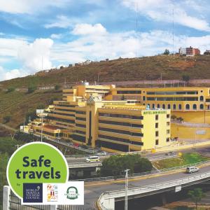 ein großes gelbes Gebäude mit einer Autobahn davor in der Unterkunft Don Miguel in Zacatecas