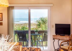 una sala de estar con una puerta corredera de cristal con vistas al océano en Unit 8213 - Ocean & Racquet Resort, en St. Augustine Beach