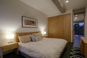 1 dormitorio con 1 cama con 2 lámparas y puerta en Apartamentos Buenos Aires en Guadalajara