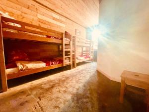 ラルプ・デュエズにあるChalet Alpe d'Huez 1850-Sea and Mountain Pleasureの二段ベッド2台とテーブルが備わる客室です。