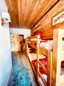 sypialnia z 3 łóżkami piętrowymi w pokoju z drewnianym sufitem w obiekcie Chalet Alpe d'Huez 1850-Sea and Mountain Pleasure w LʼAlpe-dʼHuez