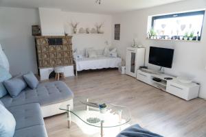ein Wohnzimmer mit Sofa und Fernseher in der Unterkunft Ferienwohnung im Idyll 1 in Hengersberg