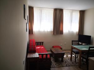 a living room with red chairs and a table at Apartments&Camping ZIP in Kremna