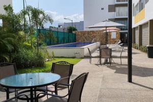 un patio con mesas y sillas y una piscina en Loft 10 min from Oro &Holy Beach, Marina, Galerias en Puerto Vallarta