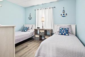 two beds in a room with blue walls at Welcome to paradise unit 2201 in Saint Augustine Beach +83 photos