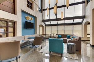a lobby with a couch and chairs and a tv at Best Western Plus Indianapolis North at Pyramids in Indianapolis