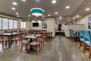 a dining room with wooden tables and blue chairs at Best Western Plus Indianapolis North at Pyramids in Indianapolis