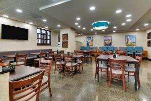 a restaurant with tables and chairs and a flat screen tv at Best Western Plus Indianapolis North at Pyramids in Indianapolis