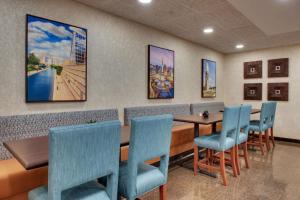 a dining room with a table and blue chairs at Best Western Plus Indianapolis North at Pyramids in Indianapolis