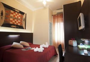 ベッラーリア・イジェア・マリーナにあるHotel Oceaniaの赤いベッドとデスクが備わるホテルルームです。