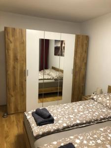 1 dormitorio con 2 camas y espejo en Neubau Wohnung Stadlau, en Viena