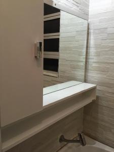 ein Badezimmer mit Spiegel und Waschbecken in der Unterkunft Kitinete confortável frente ao mar in Santos