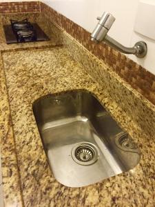 eine Küchenspüle mit einem Wasserhahn auf der Theke in der Unterkunft Kitinete confortável frente ao mar in Santos + 20 Fotos