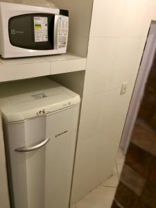 eine kleine Küche mit Mikrowelle und kleinem Kühlschrank in der Unterkunft Kitinete confortável frente ao mar in Santos