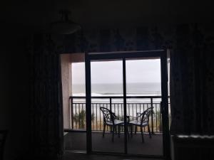 Ocean Reef Resort في ميرتل بيتش: غرفة مع شرفة مع طاولة وكراسي