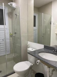uma casa de banho com um WC, um chuveiro e um lavatório. em Apartamento Rocha Sinop em Sinop