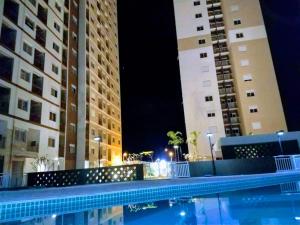 a pool in front of two tall buildings at night at Apartamento Rocha Sinop in Sinop