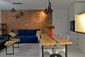 a living room with a table and a blue couch at LOFTY NA GDAŃSKIEJ in Kościerzyna